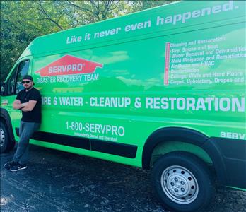 man in black shirt standing in front of green van