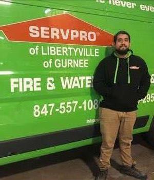 man in black in front of green van